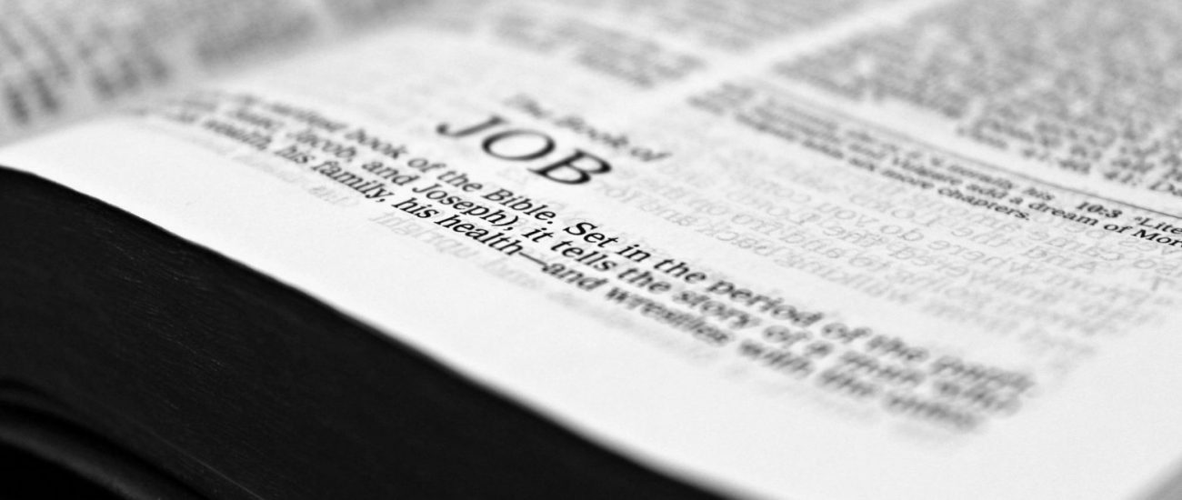 Close-up black and white image focusing on a Bible page with the Book of Job.